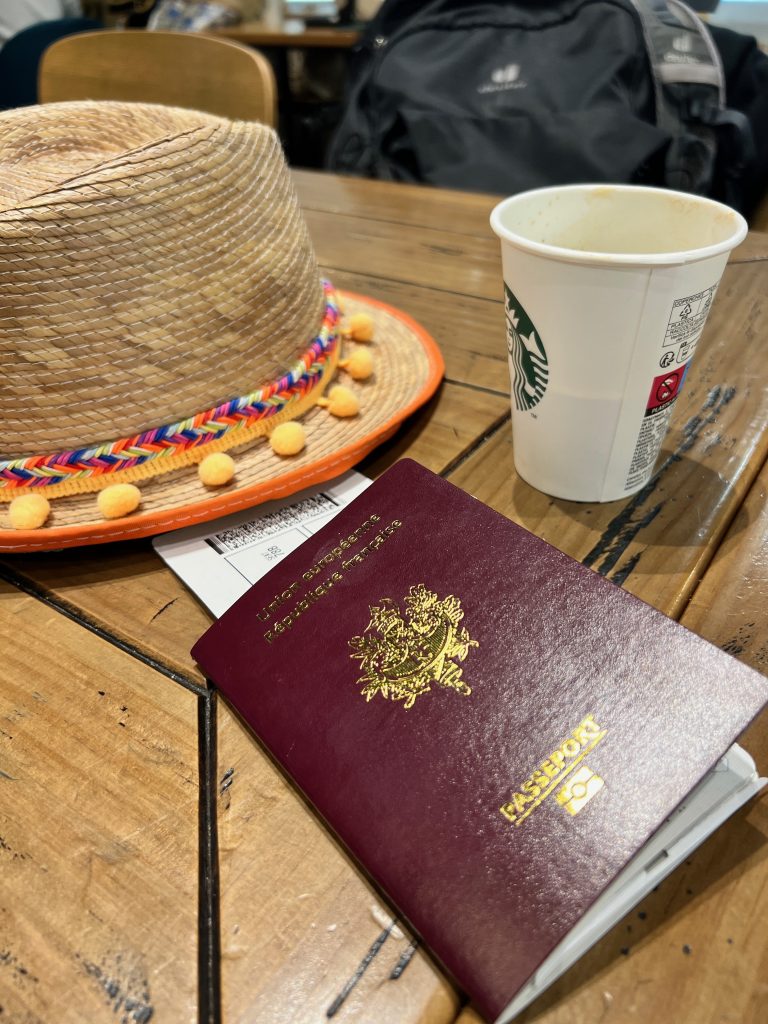 un chapeau un passeport avec billet d avion et un cafe a emporter
