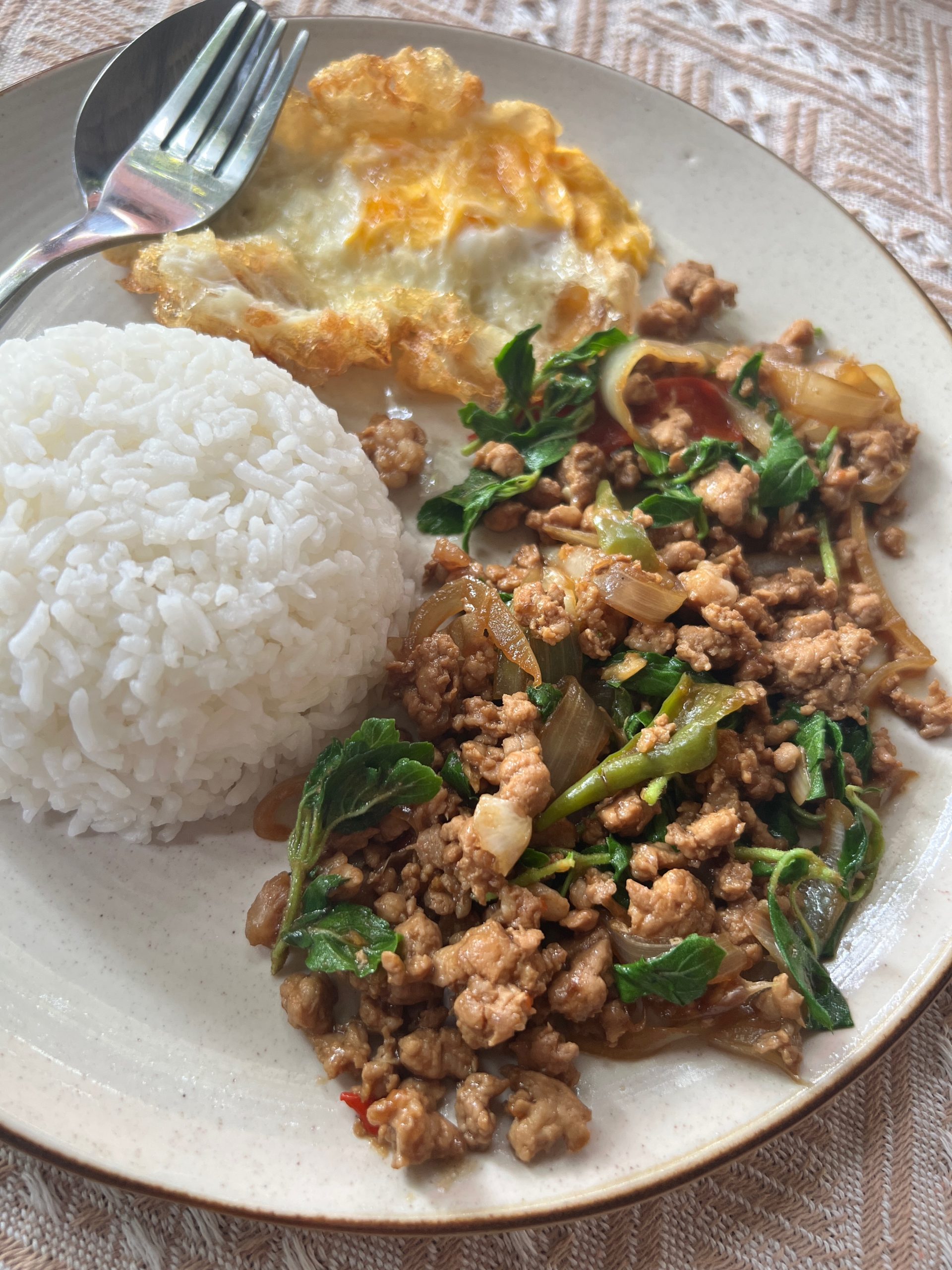 pad kra pao servi avec un oeuf frit