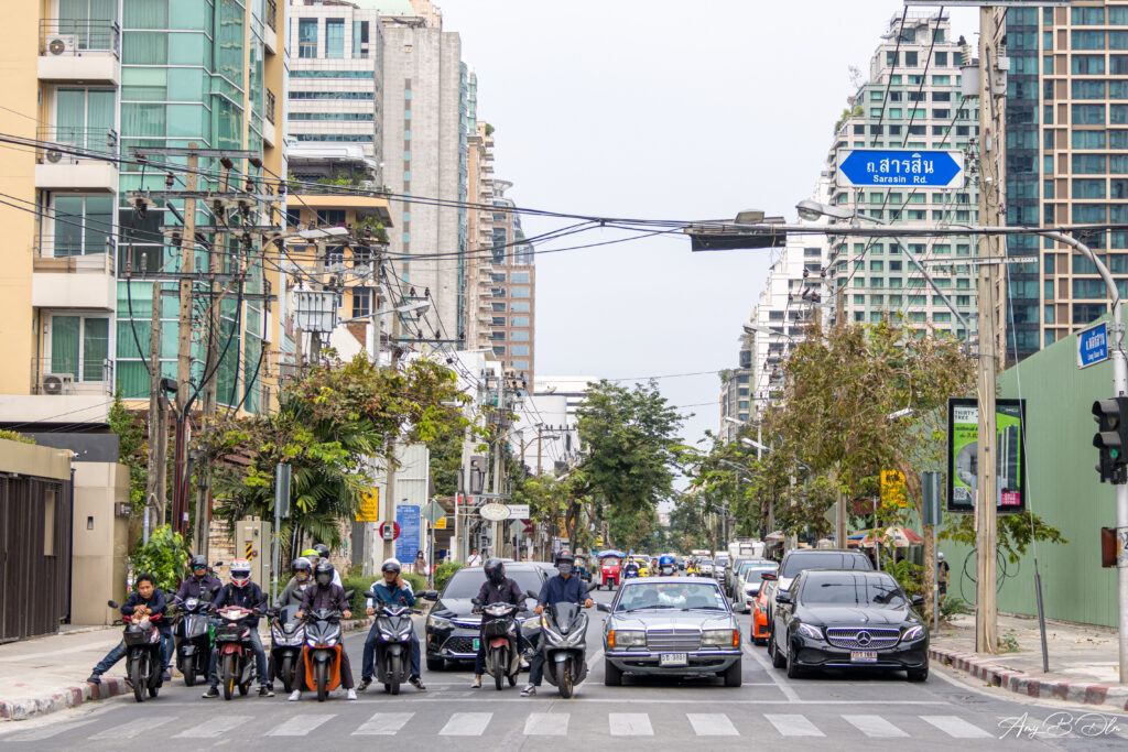 Des voitures et des deux roues attendent au feu rouge au niveau d un croisement dans Bangkok